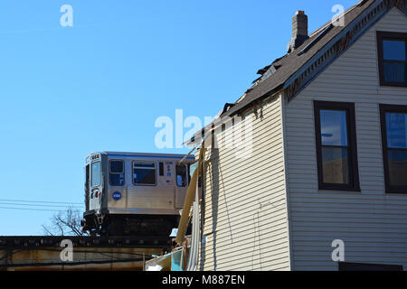 Chicago, Illinois, USA, 15 marzo 2018: costruzione equipaggi per la città di Chicago ad abbattere una casa a nord del Belmont stazione CTA. La città è la demolizione di edifici di 14 ad un costo di 320 milioni di dollari per fare la strada per la linea marrone cavalcavia. Il cavalcavia è controverso con i residenti del quartiere Lakeview che sentono che sta distruggendo il quartiere e la creazione di cicatrici permanenti. Una volta completato nel 2024 il cavalcavia è previsto per ridurre i tempi di pendolarismo da 4:00 e aggiungere capacità al rosso, viola e le linee marroni. Credito: D Valutazione Smith/Alamy Live News Foto Stock