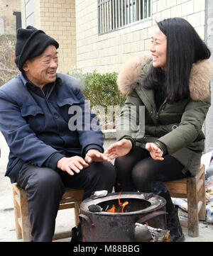 (180316) -- Pechino, 16 marzo 2018 (Xinhua) -- Cheng Ju (R) parla con un anziano abitante di dashi in villaggio della contea di Chongyang nella città di Xianning, centrale cinese della provincia di Hubei, 11 febbraio, 2018. Cheng Ju, nato nel 1990, proviene da Dashi villaggio della contea di Chongyang nella città di Xianning, centrale cinese della provincia di Hubei. In 2014, lei ha dato fino ad alta lavoro a pagamento nel sud della Cina di Guangzhou e restituito alla sua città natale per lavorare come un villaggio segretario di partito. Cheng è di nuovo lavoro ha dovuto confrontarsi con sfide come il dashi in villaggio era una volta ampiamente noto indigenza village. Negli ultimi tre anni ha l Foto Stock