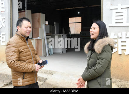 (180316) -- Pechino, 16 marzo 2018 (Xinhua) -- Cheng Ju (R) parla con un abitante di un villaggio che è tornato a casa per il business di dashi in villaggio della contea di Chongyang nella città di Xianning, centrale cinese della provincia di Hubei, 11 febbraio, 2018. Cheng Ju, nato nel 1990, proviene da Dashi villaggio della contea di Chongyang nella città di Xianning, centrale cinese della provincia di Hubei. In 2014, lei ha dato fino ad alta lavoro a pagamento nel sud della Cina di Guangzhou e restituito alla sua città natale per lavorare come un villaggio segretario di partito. Cheng è di nuovo lavoro ha dovuto confrontarsi con sfide come il dashi in villaggio era una volta ampiamente noto indigenza village. Su t Foto Stock