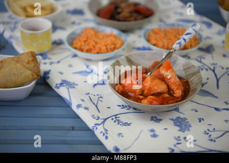 Cinese di portar via la notte con il cibo nei piatti cucinati e serviti su un tavolo Foto Stock