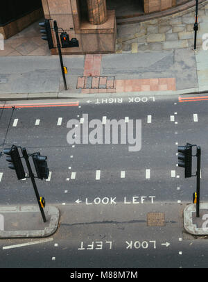 Alta vista prospettica del vuoto attraversamento pedonale della città di Londra. Look iconico di sinistra e di guardare a destra segni dipinti per assistere i turisti del traffico Foto Stock