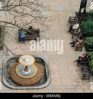 London, Regno Unito - 13 Marzo 2018: alta vista prospettica della città di Londra di lavoratori presso Whittington rilassanti giardini accanto a una fontana Foto Stock