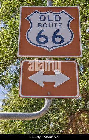 Vecchi route 66 sign in US Highway shield su uno sfondo di colore marrone con le frecce di direzione Foto Stock