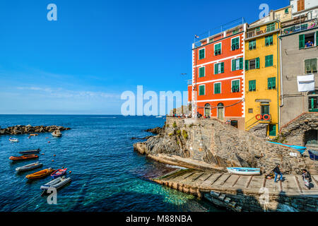 Il porto e la barca lanciare a Riomaggiore, Italia, parte delle Cinque Terre sulla costa ligure con barche in mare e case colorate Foto Stock