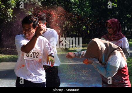 Bogor, Indonesia. 16 Mar, 2018. I partecipanti passano attraverso le nuvole di polvere colorata generata da volontari durante la grande "4K COLOUR RUN organizzato da informazioni geospaziali agenzia (grande) Il 16 marzo 2018 in Cibinong, West Java, Indonesia.I partecipanti coperti in gesso colorato in polvere ha preso parte alla gara che è stato ispirato dalla Indian Holi festival. Credito: Risa Krisadhi/Pacific Press/Alamy Live News Foto Stock