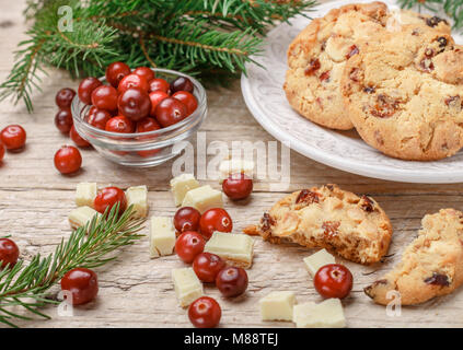 Fatti in casa a base di mirtillo palustre di Natale i biscotti con il cioccolato bianco in una ciotola sul tavolo. Stile rustico. Messa a fuoco selettiva Foto Stock