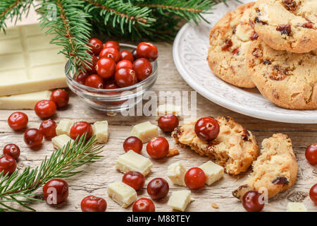 Fatti in casa a base di mirtillo palustre di Natale i biscotti con il cioccolato bianco in una ciotola sul tavolo. Stile rustico. Messa a fuoco selettiva Foto Stock