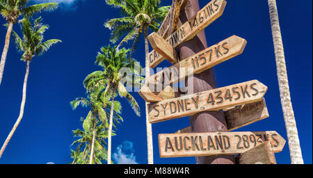 Strada segno sulla spiaggia che indica le direzioni per diversi luoghi del mondo, prese a Samoa Foto Stock