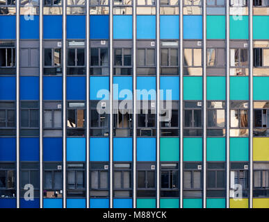 Facciata di un moderno grattacielo con panals colorate e finestre di vetro nel quartiere commerciale di una città Foto Stock