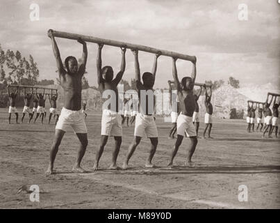 1940s East Africa - esercito di soldati segnalatori acustici Askari facendo addestramento fisico Foto Stock