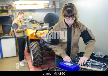 Maschio e femmina meccanica con quad Foto Stock