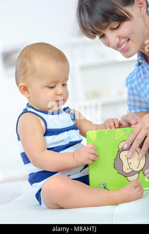 Donna flipping picture book con il bambino Foto Stock