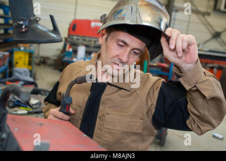 Saldatore meccanico di ispezionare il materiale Foto Stock