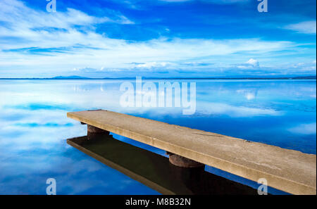 Pontile o molo, blu tramonto panoramico paesaggio. Laguna di Orbetello con la riflessione, Argentario, Toscana, Italia. Foto Stock