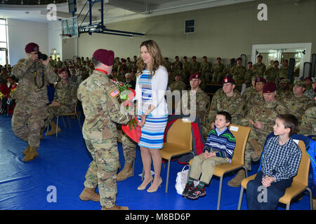 La sig.ra Sarah, moglie di comando in arrivo Sgt. Maj Erick E. Ochs, riceve un mazzo di rose rosse da un U.S. Paracadutista durante il cambio di responsabilità per il 173rd Brigata Aerea alla Caserma del Din a Vicenza, Italia, 27 febbraio 2018. Il 173rd Brigata aerea è l'U.S. Esercito di risposta di emergenza forza in Europa, in grado di proiettare le forze di pronto ovunque negli Stati Uniti Europeo, Africa Centrale o comandi in aree di responsabilità. (U.S. Esercito Foto Stock