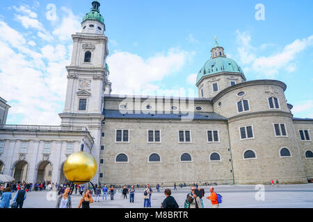 SALZBURG AUSTRIA - 6 settembre 2017; persone che passano dalla grande sfera dorata con uomo sulla sommità da scultura dell'artista Stephan Balkenhol in Piazza Capital Foto Stock