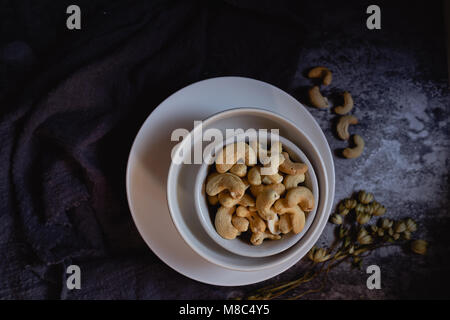 Noci di anacardio in bianco a bocce. Sfondo scuro. Foto Stock