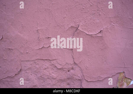 Un frammento di una parete rosa con graffi e urti Foto Stock