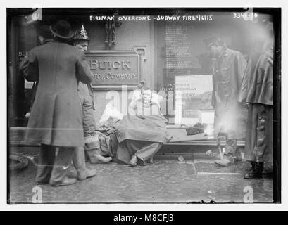 Un'immagine drammatica di un vigile del fuoco sopraffatto dal fumo e dalle fiamme durante un incendio della metropolitana a New York il 6 gennaio 1915. La foto cattura la natura pericolosa ed eroica degli incendi negli ambienti urbani dei primi anni del XX secolo. Foto Stock