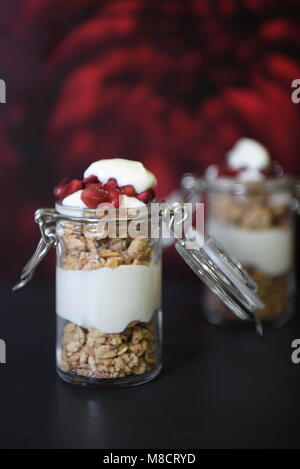 Cibo sano pot con muesli e cereali yogurt su nero Foto Stock