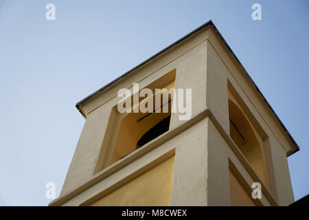 Il campanile della chiesa cattolica contro il cielo blu e chiaro vista dal basso. Foto Stock