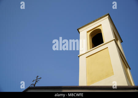 Il campanile della chiesa cattolica contro il cielo blu e chiaro vista dal basso. Foto Stock