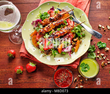 Una piastra di verde con spiedini di pollo e ispirazione estiva Foto Stock