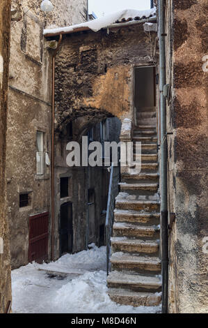 Vicolo medievale innevato con scalinata che conduce alla casa e arco di comunicazione tra diverse case nel borgo medievale di Scanno.Abruzzo Foto Stock