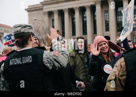 I manifestanti alta cinque donne nazionali membri di guardia mentre marcia nel femminile marzo su Washington D.C., Gennaio 21, 2017