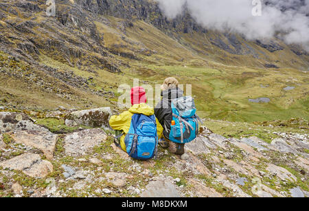 Due ragazzi seduti su una collina, guardando a vista, vista posteriore, Ventilla, La Paz, Bolivia, Sud America Foto Stock