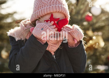 La ragazza di albero di natale foresta che copre la sua gli occhi con le decorazioni di Natale Foto Stock