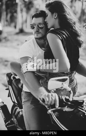 Giovane donna a cavallo fidanzato sul motociclo, Krabi, Thailandia, B&W Foto Stock