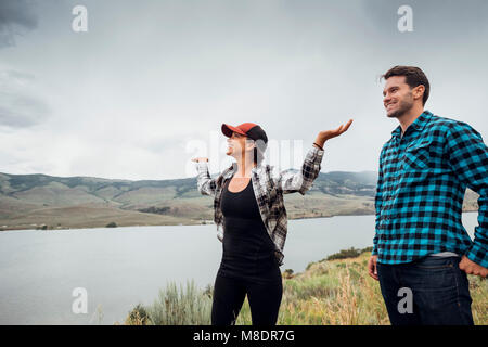 Giovane camminare vicino a serbatoio Dillon, giovane donna di bracci sollevati, Silverthorne, Colorado, STATI UNITI D'AMERICA Foto Stock