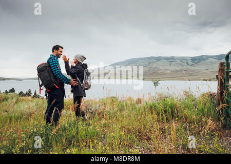 Escursionismo coppia, in piedi accanto al serbatoio di Dillon, faccia a faccia, Silverthorne, Colorado, STATI UNITI D'AMERICA Foto Stock