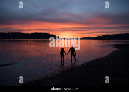 Coppia sulla spiaggia al tramonto Foto Stock