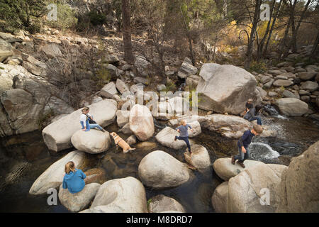 Famiglia giocando sulle rocce nel fiume, Lake Arrowhead, CALIFORNIA, STATI UNITI D'AMERICA Foto Stock