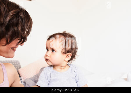 Madre seduta faccia a faccia con la nostra bambina, bimba con espressione triste Foto Stock
