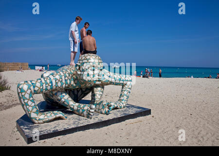 I giovani in piedi su un Rabarama scultura alla spiaggia di Pampelonne, popolare spiaggia di Saint Tropez, riviera francese, il sud della Francia, Cote d'Azur, in Francia Foto Stock