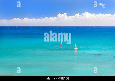 Windsurf con il red sail passeggiate sul mare. Vista da sunny Livadi Spiaggia nel villaggio di Bali. Rethimno, Creta Grecia. Extreme sports acquatici come recre attivo Foto Stock