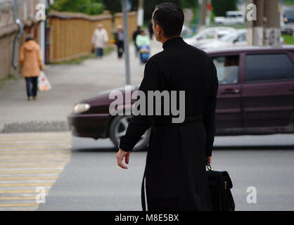 Sacerdote su sfondo scuro Foto Stock