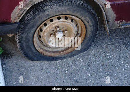 Sgonfiato pneumatico danneggiato su auto ruota. Foto Stock