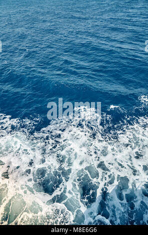 Sentiero in schiuma bianca sulla superficie del mare dietro una vista in movimento della nave dall'alto Foto Stock