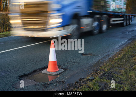 Autocarro passando grande cono gigante di marcatura buche sulla strada di campagna dello Yorkshire York Regno Unito Foto Stock