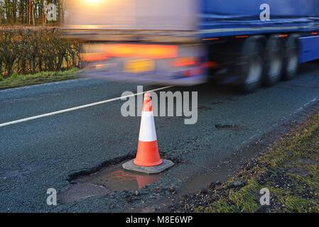 Autocarro passando grande cono gigante di marcatura buche sulla strada di campagna dello Yorkshire York Regno Unito Foto Stock