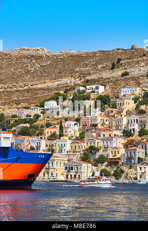 Multi-case colorate sulla costa rocciosa di Simi Isola Foto Stock