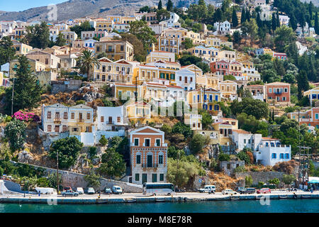 Multi-case colorate sulla costa rocciosa di Simi Isola Foto Stock