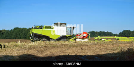 Due macchine agricole che operano nel campo dei terreni agricoli, ain macchine da raccolta operano nel campo Foto Stock