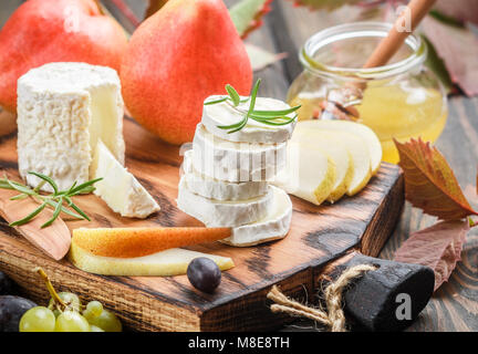 Formaggio di capra con frutta e miele. Camembert. Bree. Uva, pera e rosmarino. Vino Gourmet snack. Messa a fuoco selettiva Foto Stock