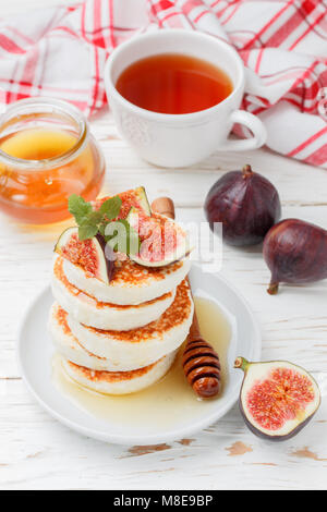 Formaggio di casa frittelle con miele e frutti di bosco freschi figg. Syrniki. Tradizionale gustosa e sana prima colazione. Messa a fuoco selettiva Foto Stock