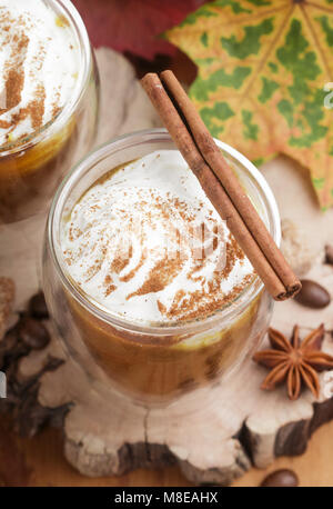 Latte macchiato di zucca o frullati con panna e spezie-cannella, anice stellato, caffè. A freddo o a caldo rientrano bere. Messa a fuoco selettiva Foto Stock